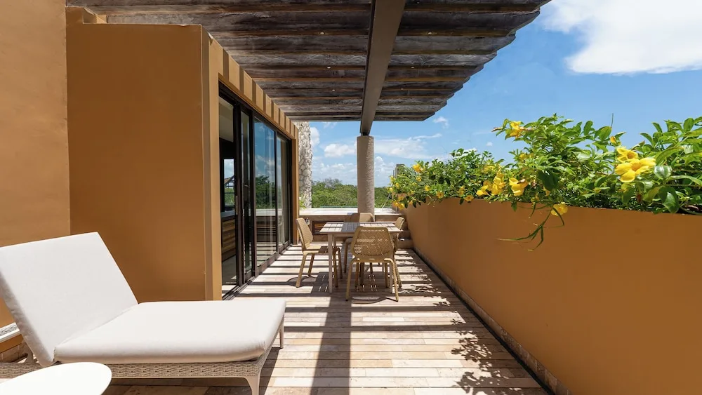 Master Suite terrace with lounger and outdoor dining at Hotel Xcaret Mexico.