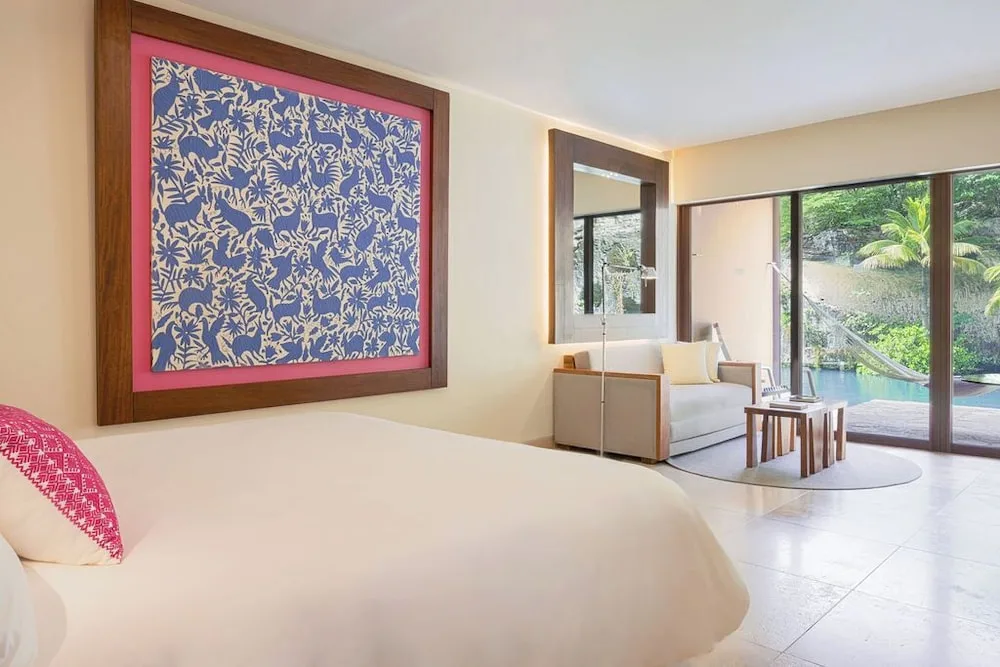 Suite River Jump king bed and lounge by sliding doors at Hotel Xcaret Mexico.
