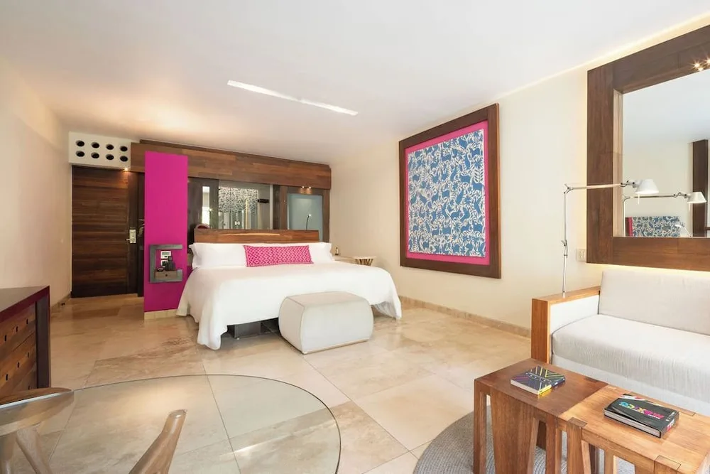 Suite River Jump room with king bed and sitting area at Hotel Xcaret Mexico.