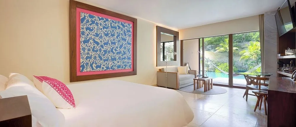 Suite River Jump king bed with terrace and water view at Hotel Xcaret Mexico.