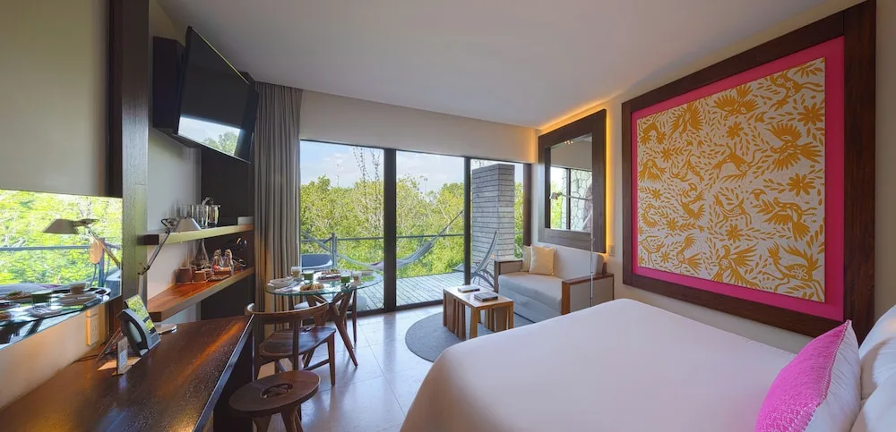 River Spa Suite king bed with balcony doors and hammock at Hotel Xcaret Mexico.