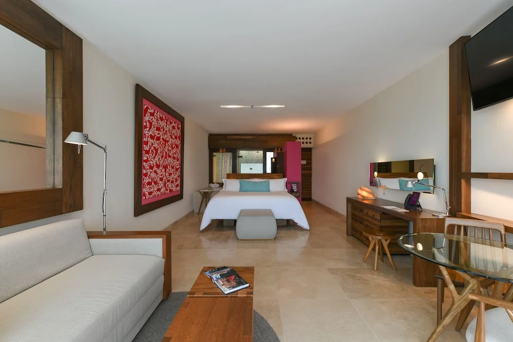 River Spa Suite with king bed, sofa and desk at Hotel Xcaret Mexico.