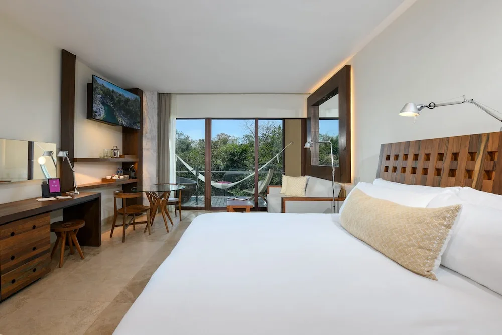 Suite River king bed, work desk, and balcony hammock at Hotel Xcaret Mexico.