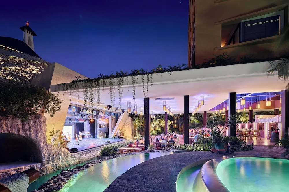 Open-air dinner theater with stage, diners and water features at Hotel Xcaret Mexico.