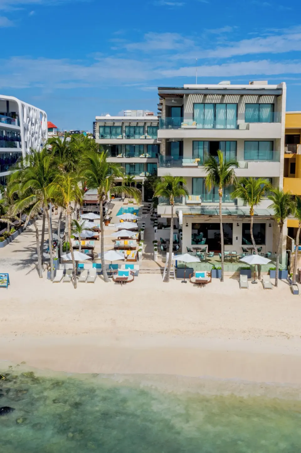 Beachfront building and lounge chairs at Hyatt Centric Playa del Carmen - Downtown House & Beach House.