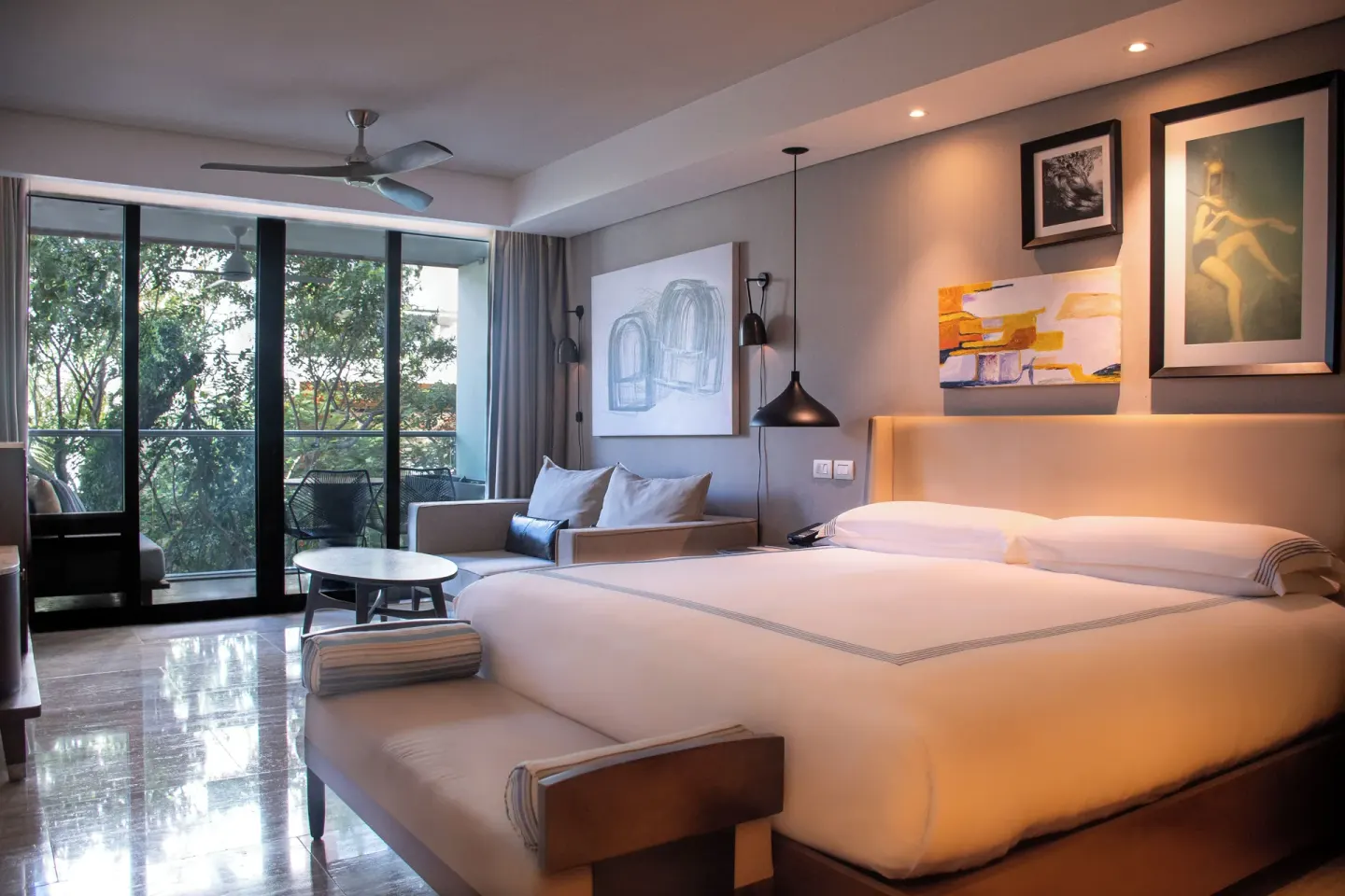 Warmly lit king bed room with balcony and sofa at Hyatt Centric Playa del Carmen - Downtown House & Beach House.