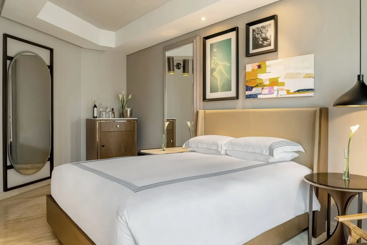 Guest room king bed with wall art and mirror at Hyatt Centric Playa del Carmen - Downtown House & Beach House.