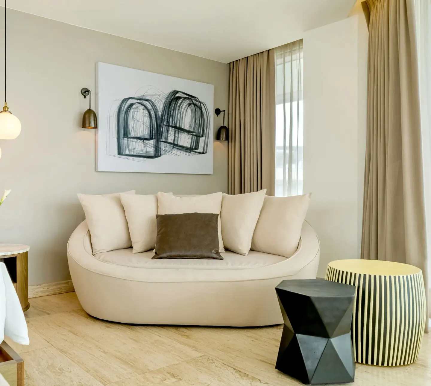 Curved sofa seating nook with abstract art at Hyatt Centric Playa del Carmen - Downtown House & Beach House.