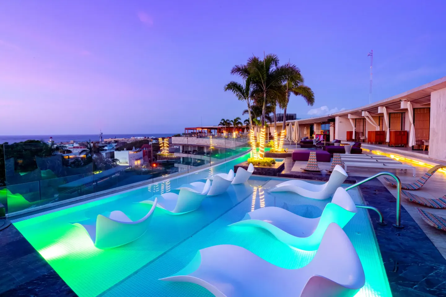 Illuminated rooftop pool at dusk at Hyatt Centric Playa del Carmen - Downtown House & Beach House.