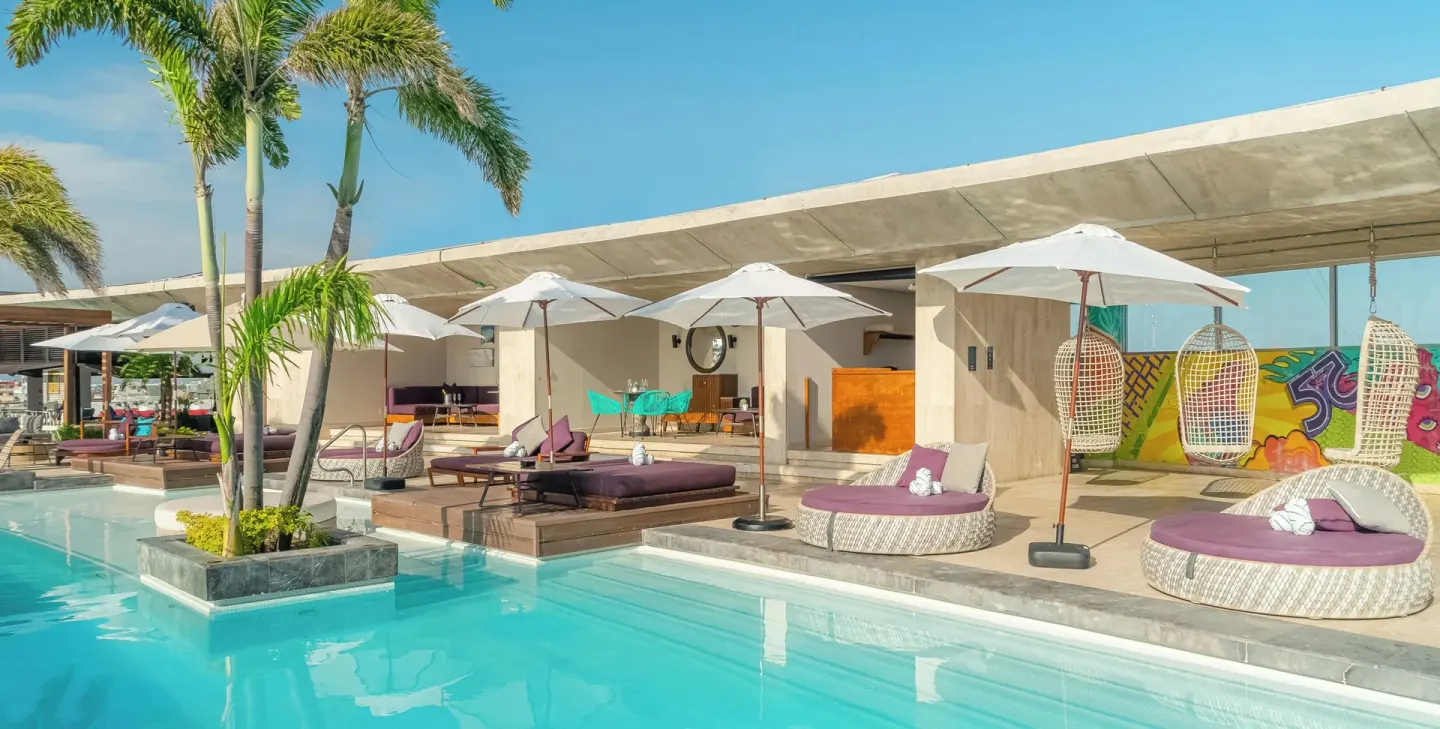 Poolside daybeds and umbrellas at Hyatt Centric Playa del Carmen - Downtown House & Beach House.