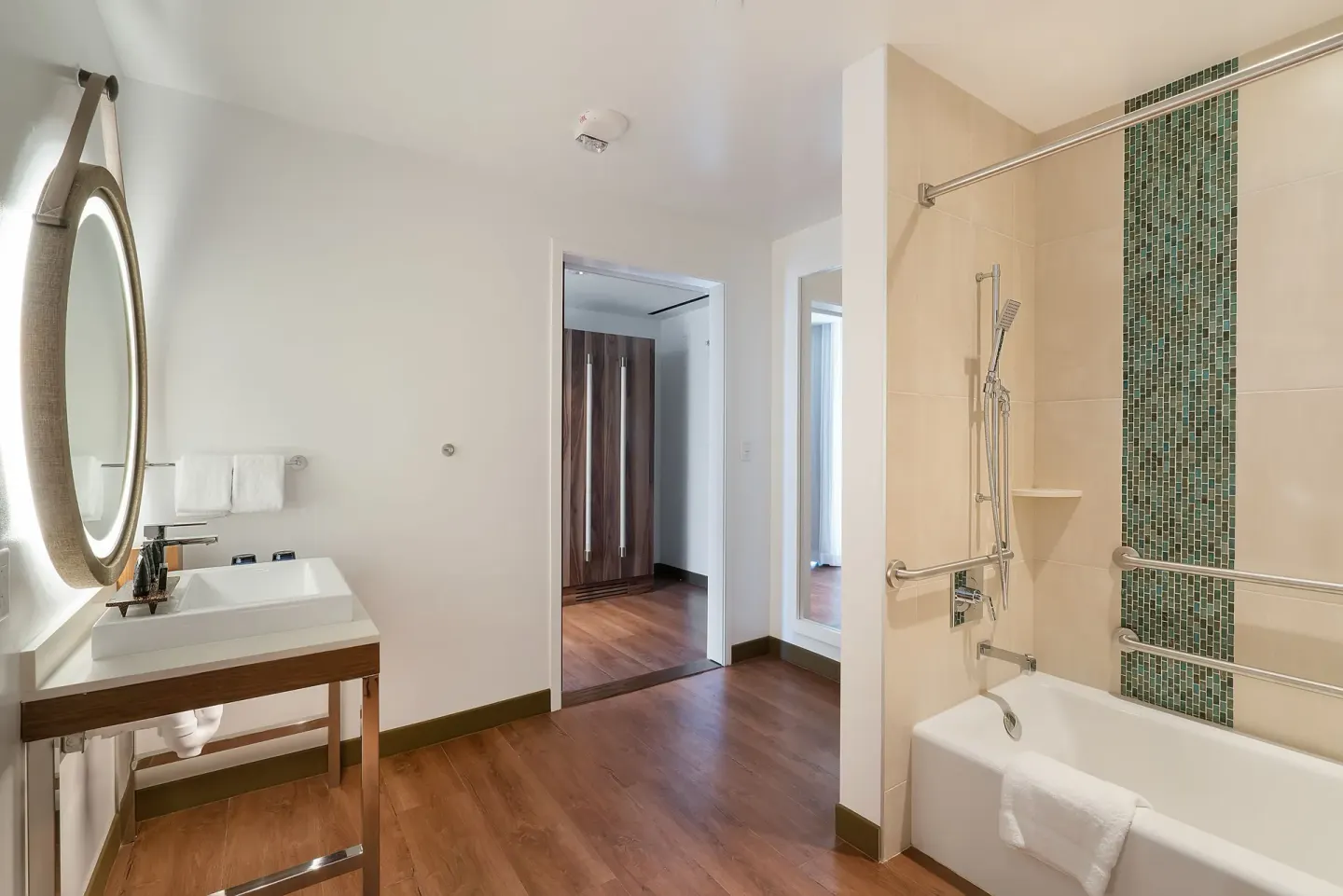 Accessible bathroom with tub, vanity and round mirror at Hyatt Centric Waikiki Beach.