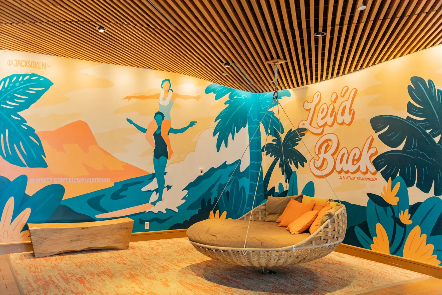 Colorful lounge mural and hanging wicker daybed at Hyatt Centric Waikiki Beach.