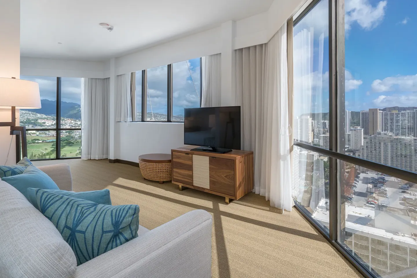 Corner living area with TV and city views at Hyatt Centric Waikiki Beach.