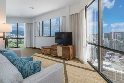 Corner living area with TV and city views at Hyatt Centric Waikiki Beach.