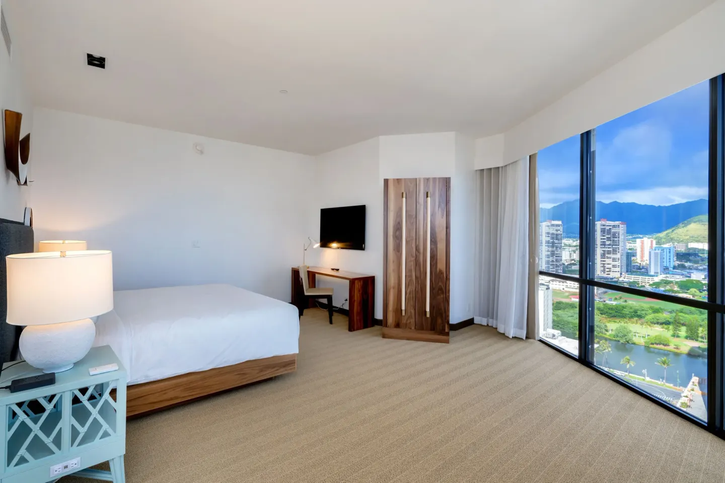 King-bed guest room with desk and city-mountain view at Hyatt Centric Waikiki Beach.