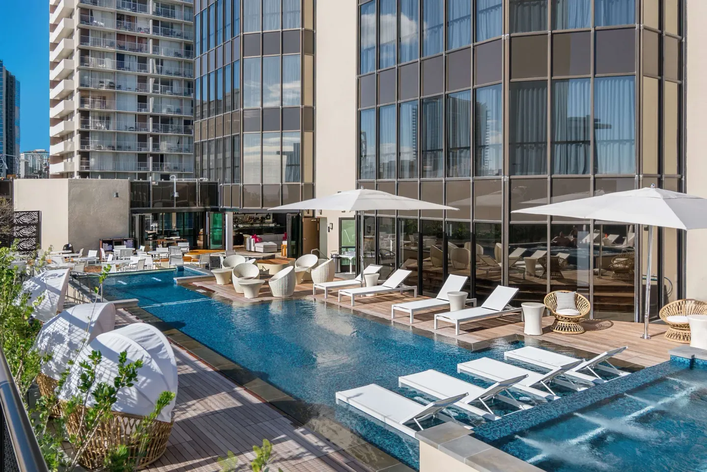 Rooftop pool deck with loungers and umbrellas at Hyatt Centric Waikiki Beach.