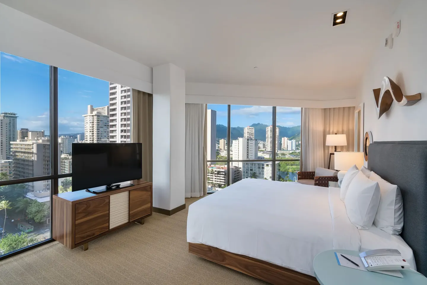 Deluxe king room with large windows and mountain city views at Hyatt Centric Waikiki Beach.
