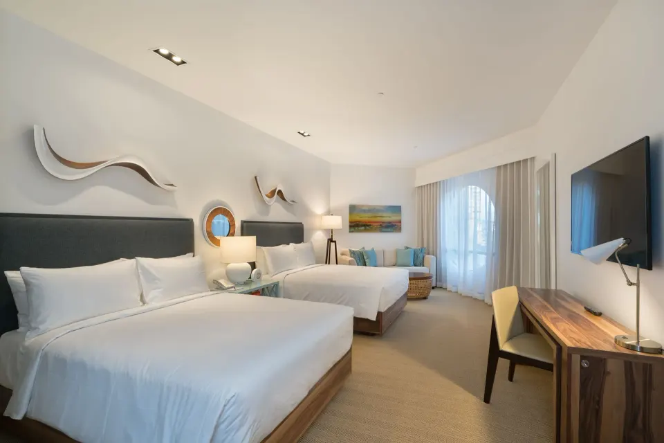 Deluxe room with two beds, desk, seating area, and TV at Hyatt Centric Waikiki Beach.