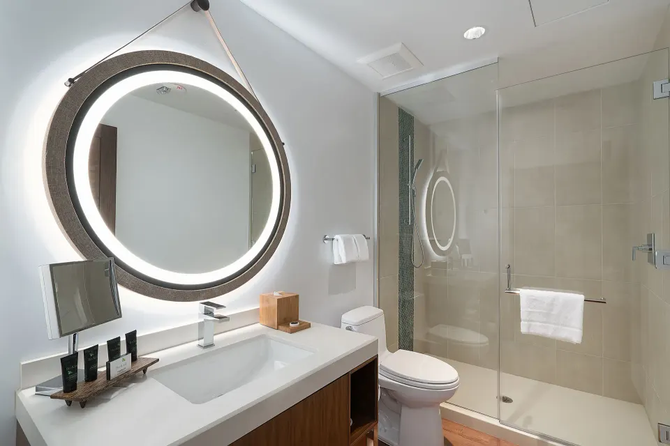 Guest room bathroom with vanity, toilet, and glass shower at Hyatt Centric Waikiki Beach.