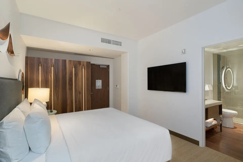 High-floor king room with wall TV and bathroom doorway at Hyatt Centric Waikiki Beach.
