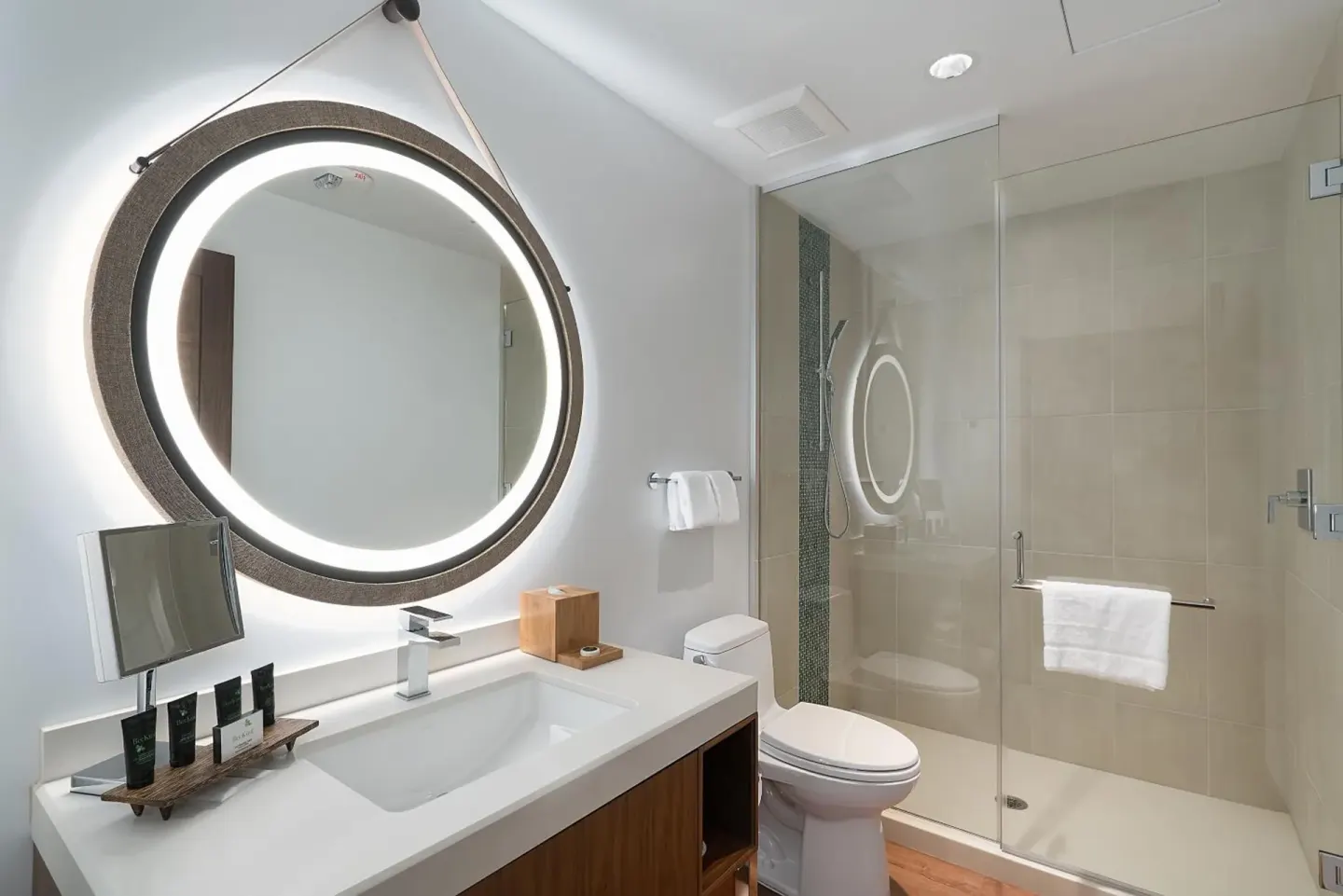 High floor room bathroom with lit round mirror and glass shower at Hyatt Centric Waikiki Beach.
