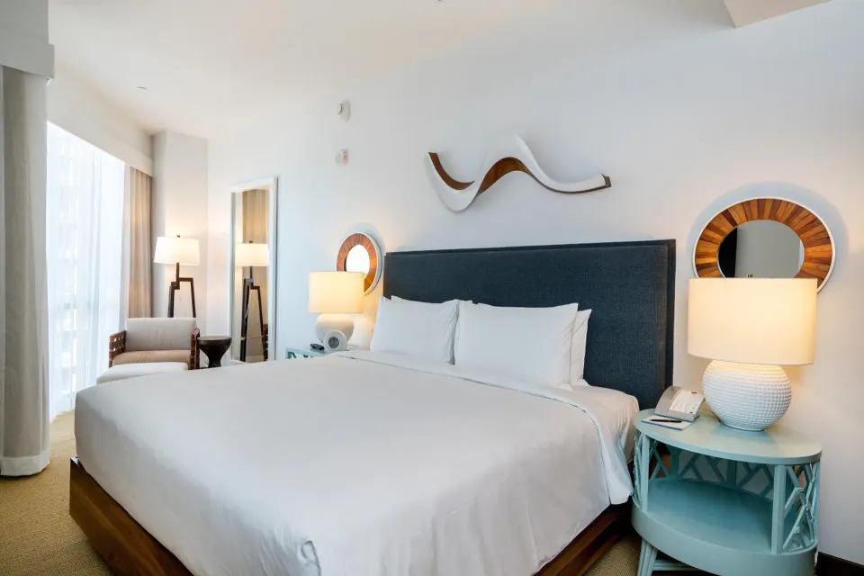 High floor room with king bed and bedside lamps at Hyatt Centric Waikiki Beach.