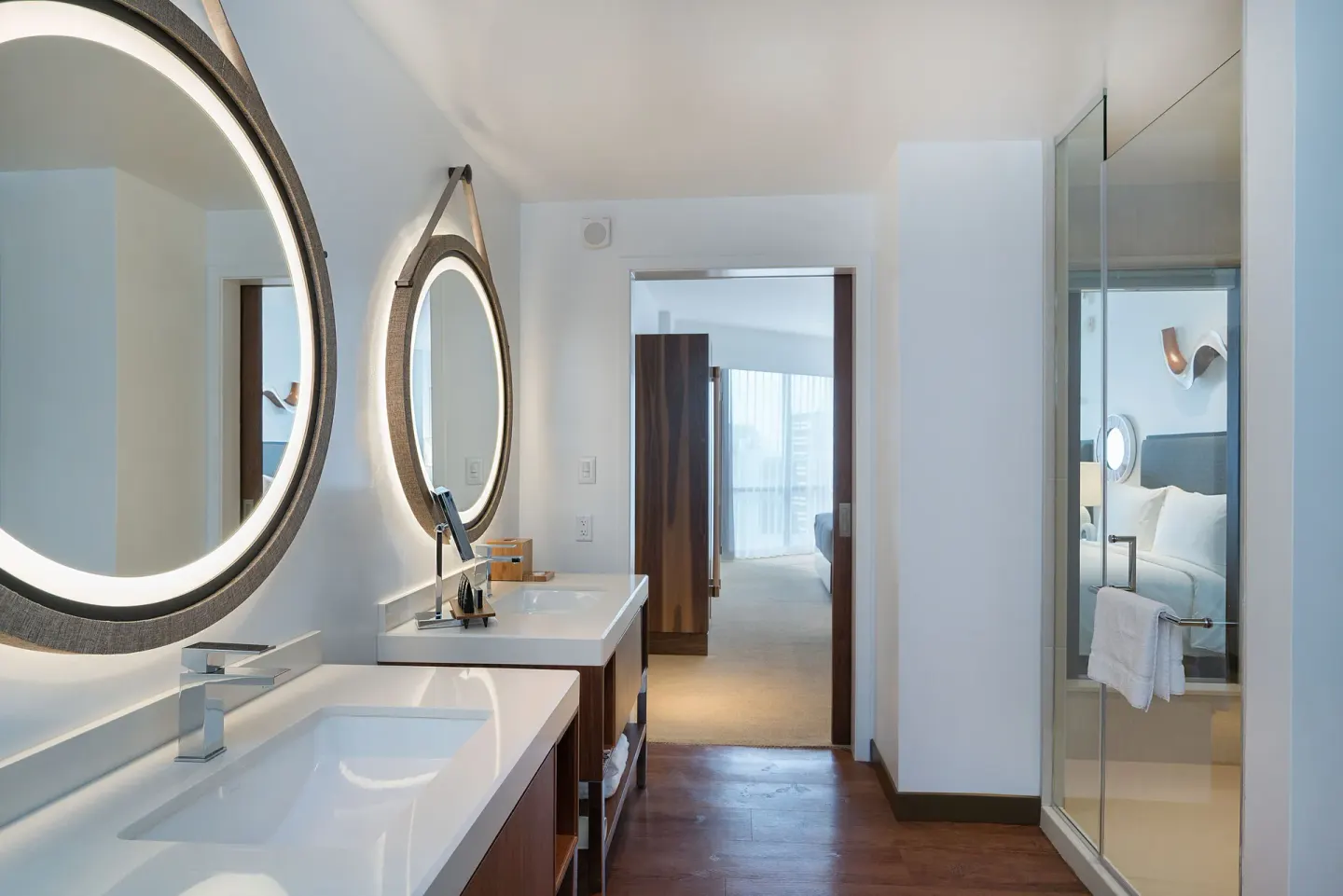 Ocean View room bathroom with dual vanities and bedroom beyond at Hyatt Centric Waikiki Beach.