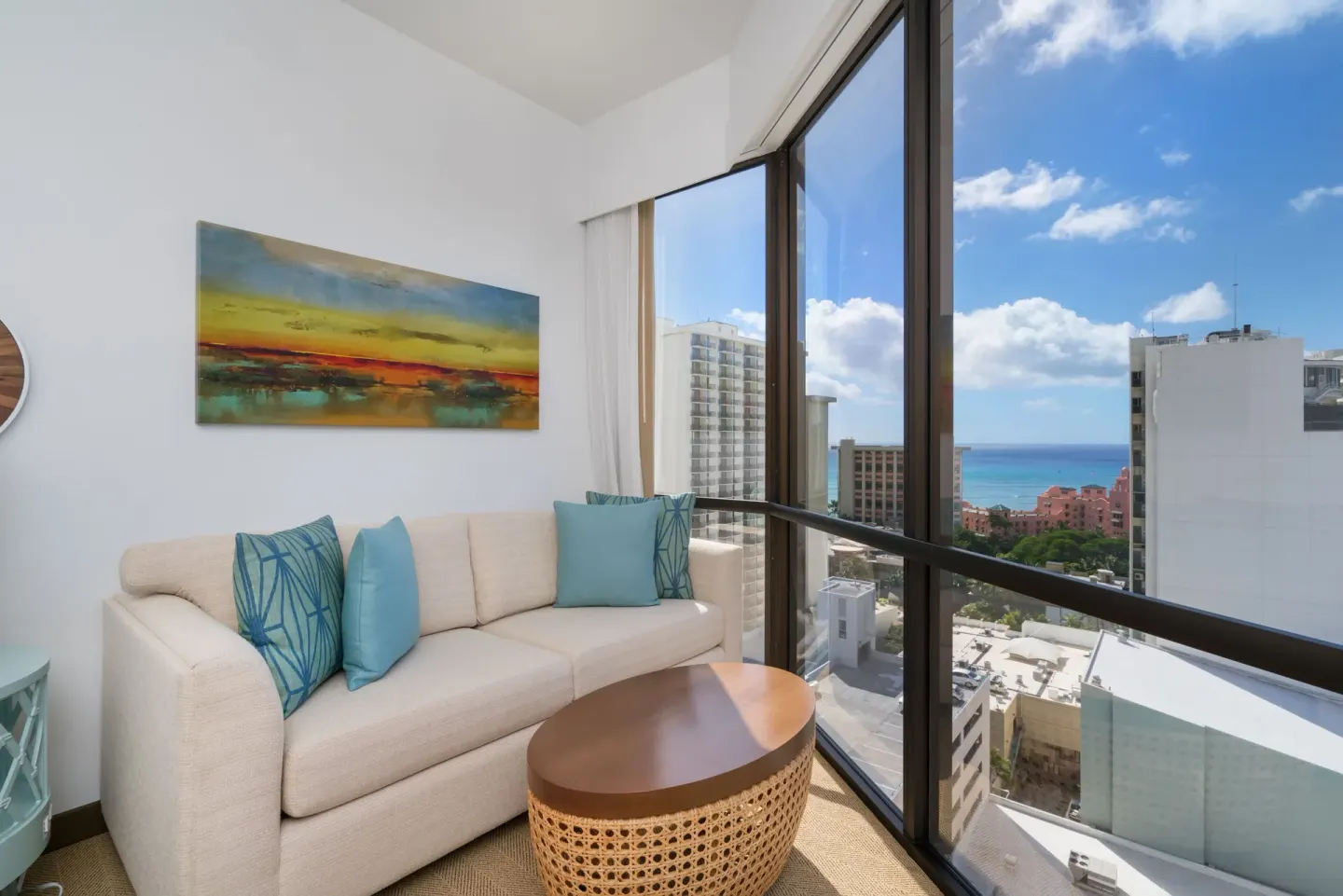 Ocean View room sitting area with sofa and floor-to-ceiling windows at Hyatt Centric Waikiki Beach.