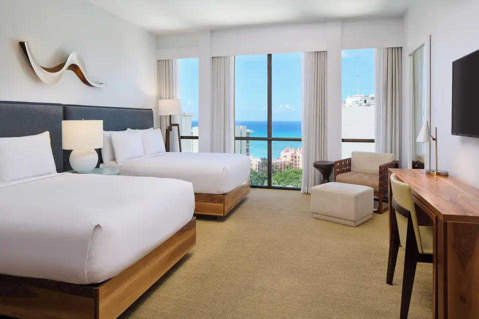 Ocean view guest room with two beds and desk at Hyatt Centric Waikiki Beach.