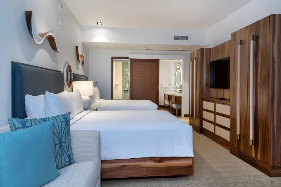 Two-bed guest room with wood cabinetry at Hyatt Centric Waikiki Beach.