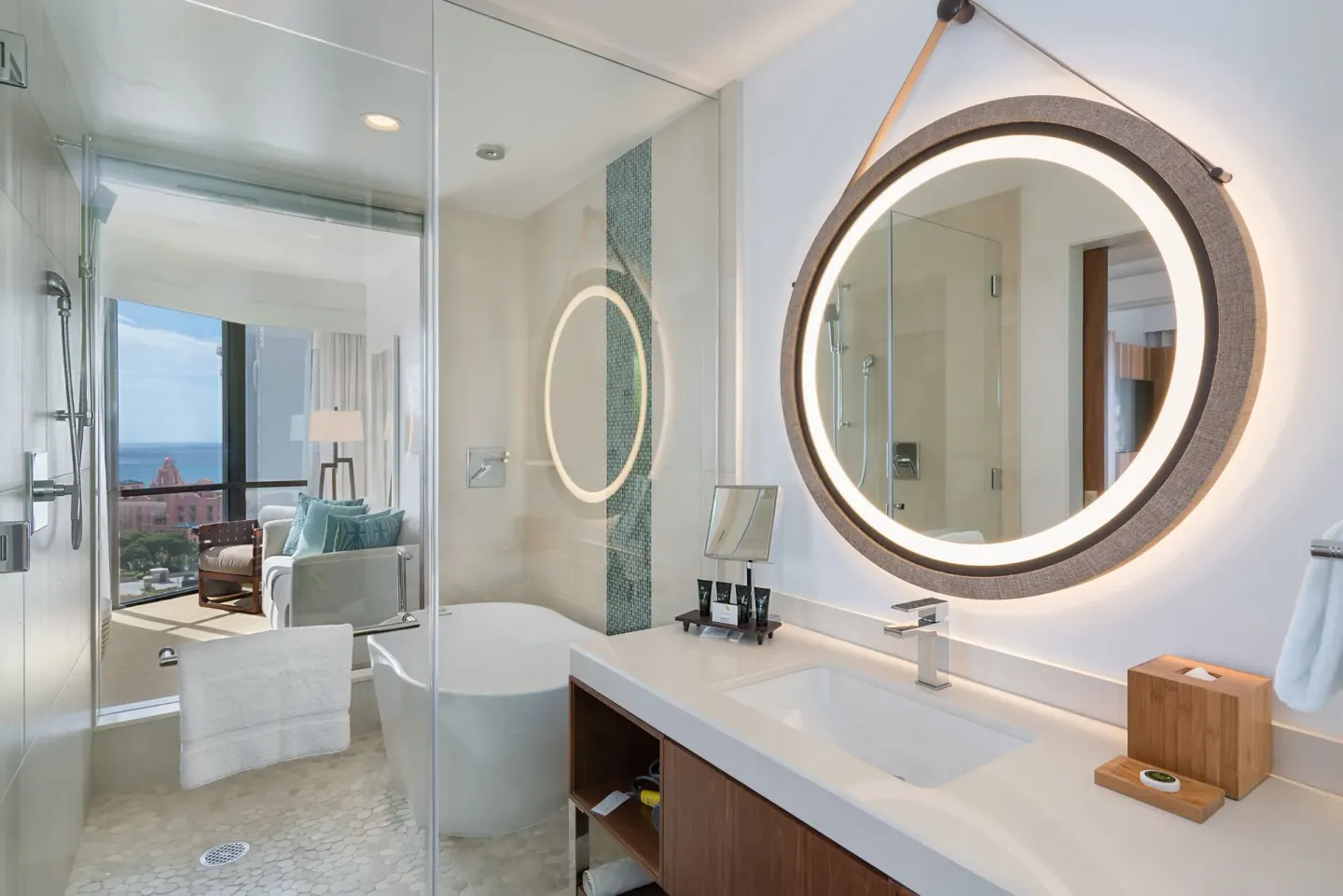 Ocean View Suite bathroom with glass shower, tub and illuminated mirror at Hyatt Centric Waikiki Beach.