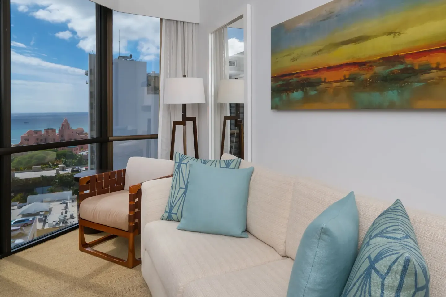 Ocean View Suite sofa and chair beside large windows at Hyatt Centric Waikiki Beach.