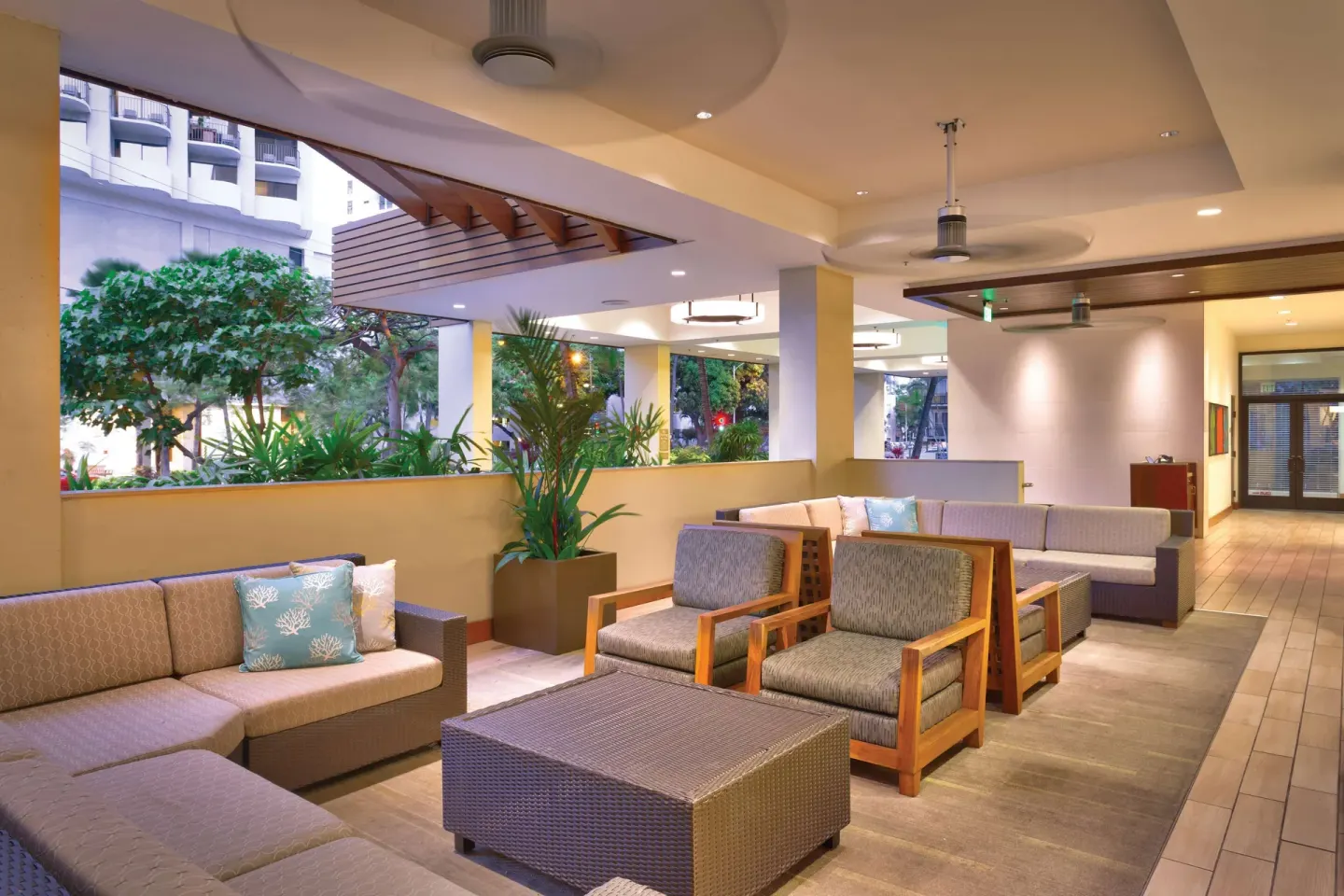 Covered lounge seating near greenery at Hyatt Place Waikiki Beach.