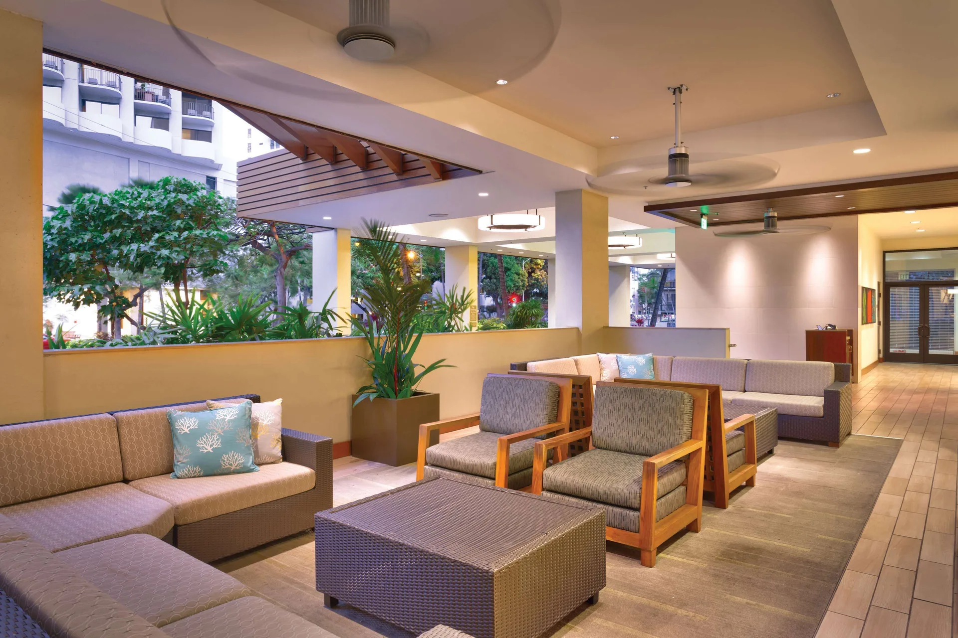 Covered lounge seating near greenery at Hyatt Place Waikiki Beach.
