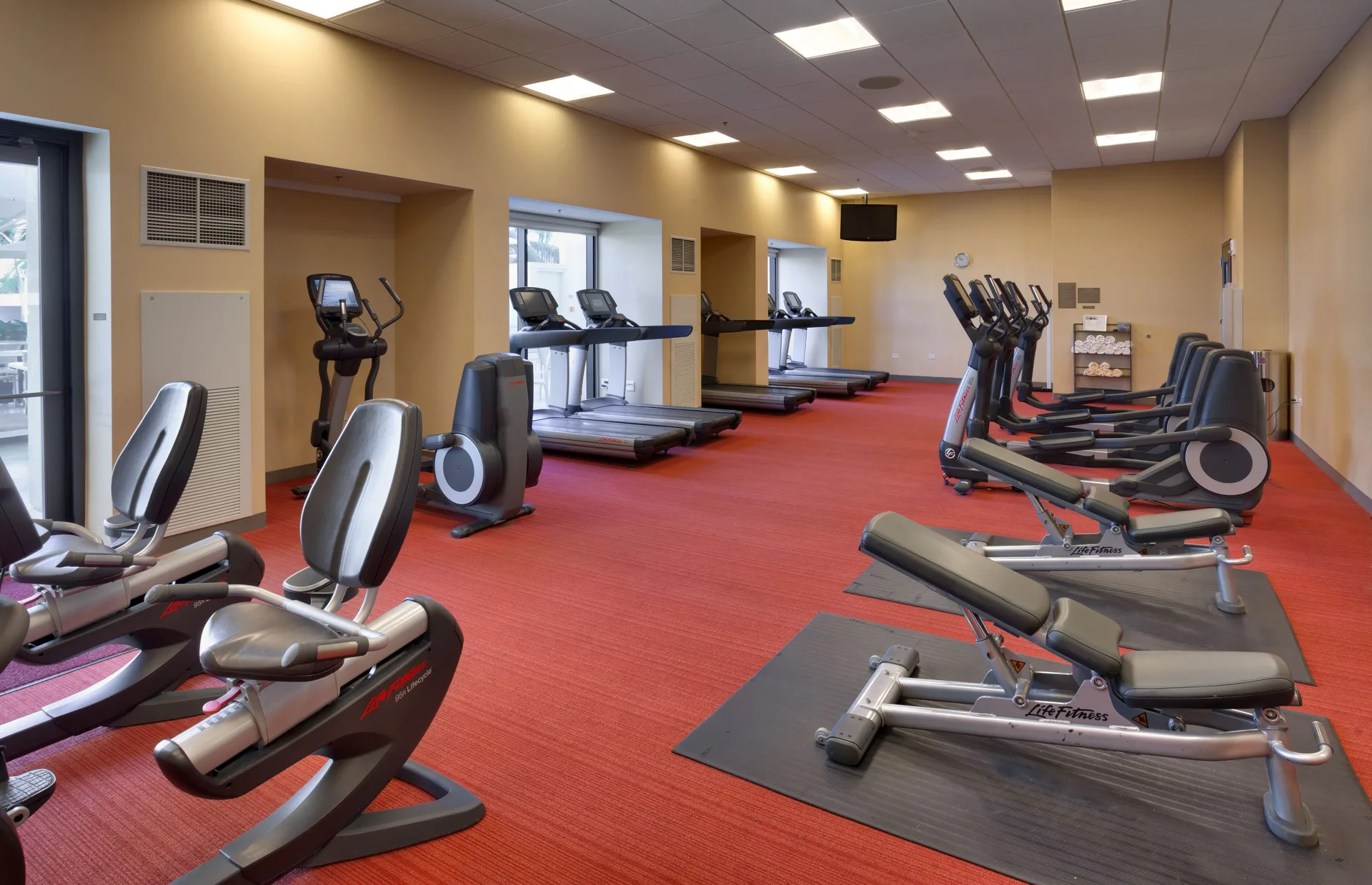 Fitness center with treadmills, ellipticals, and benches at Hyatt Place Waikiki Beach.
