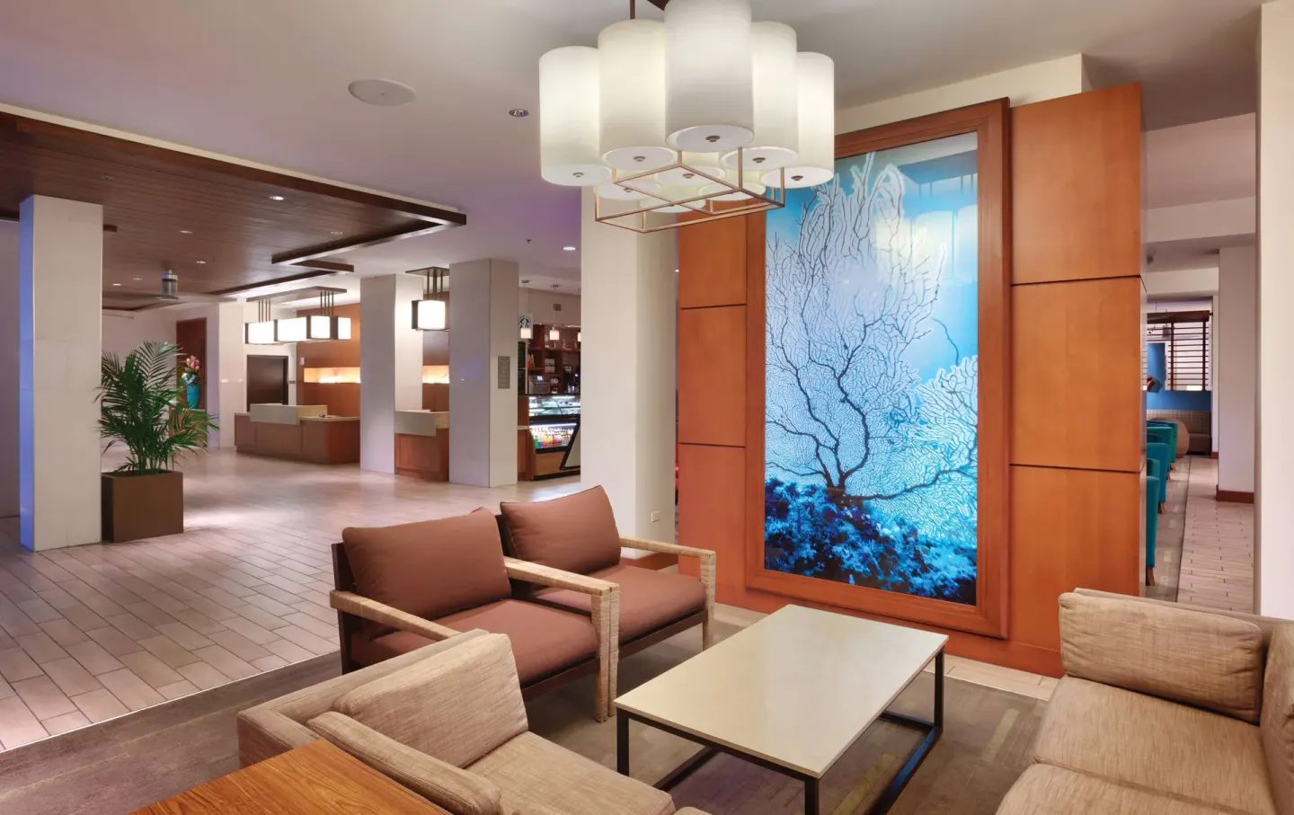 Lobby seating area with ocean-inspired wall art at Hyatt Place Waikiki Beach.