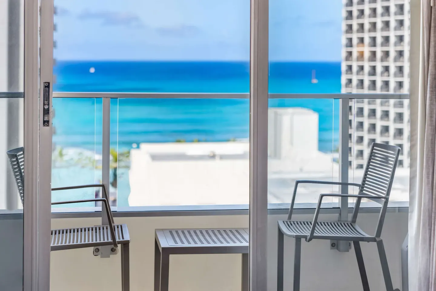 Balcony chairs overlooking the ocean at Hyatt Place Waikiki Beach.