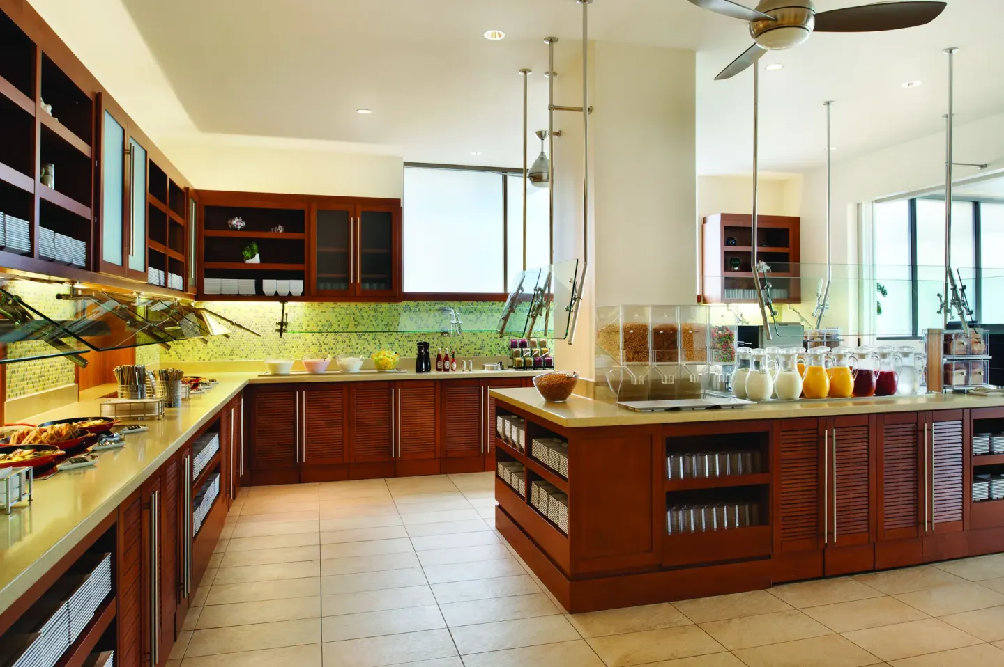 Breakfast buffet counter with juices, cereal, and serving stations at Hyatt Place Waikiki Beach.