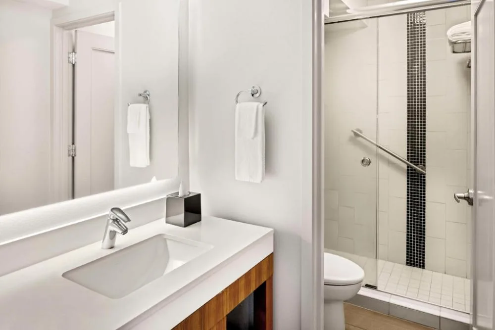 Guest room bathroom with vanity and walk-in shower at Hyatt Place Waikiki Beach.
