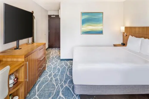 Bed Mountain View room with wood furniture and patterned carpet at Hyatt Place Waikiki Beach.