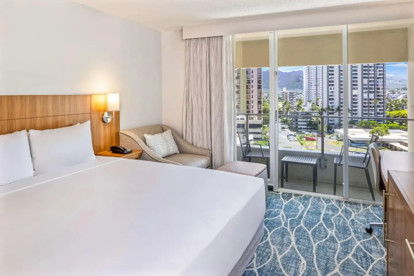 City View king bed guest room with balcony seating at Hyatt Place Waikiki Beach.