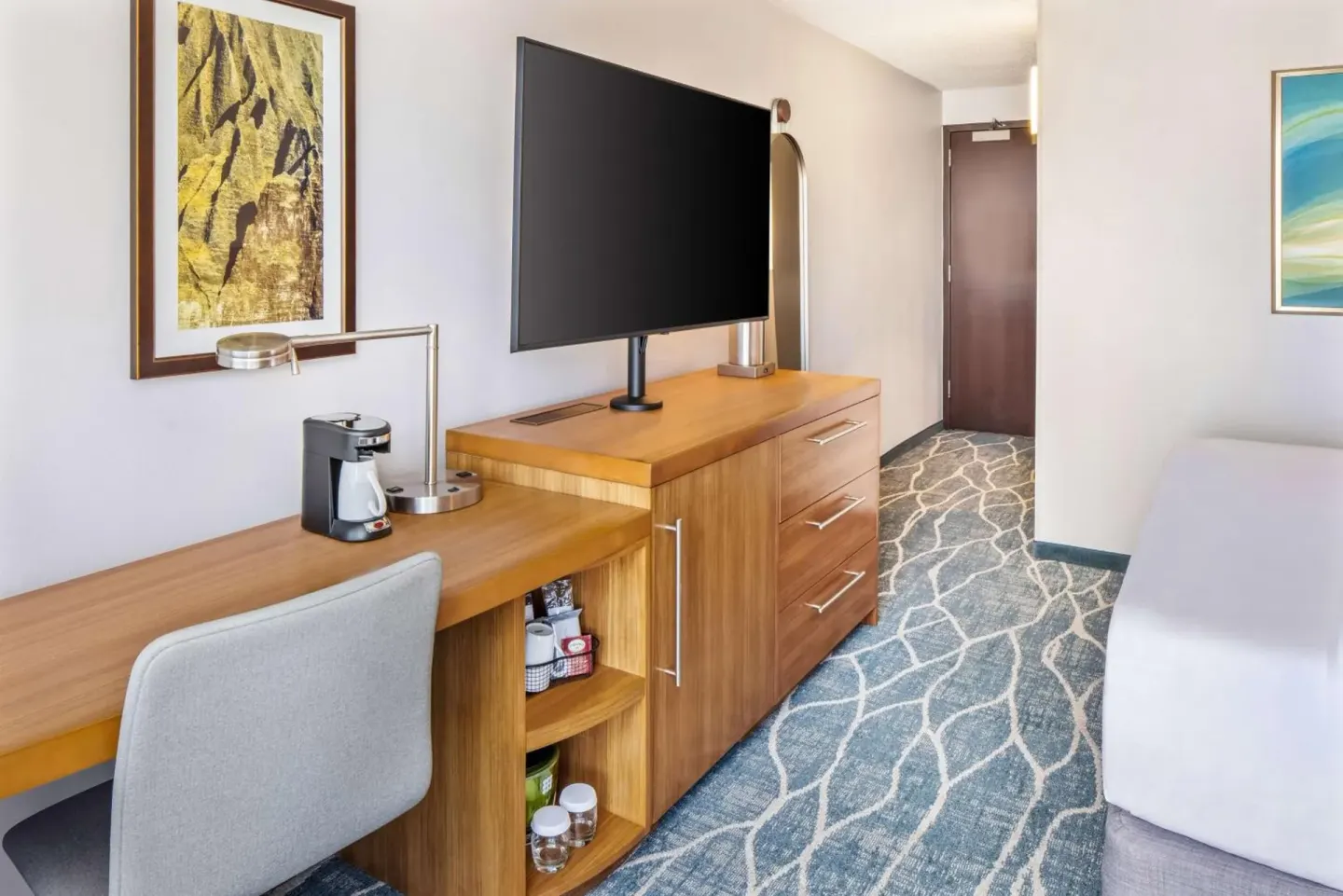 City View guest room desk, TV, dresser, and bed edge at Hyatt Place Waikiki Beach.
