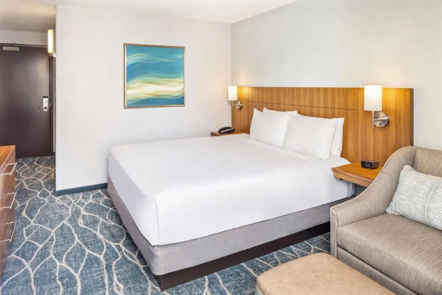 City View king bed guest room with armchair and wall art at Hyatt Place Waikiki Beach.