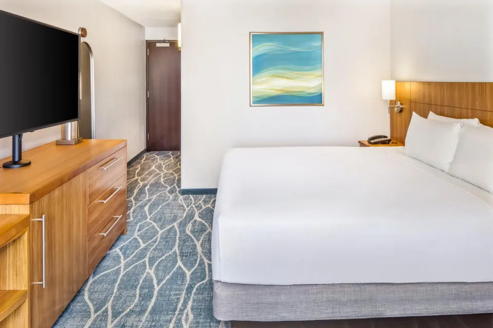 City view guest room bed with TV and dresser at Hyatt Place Waikiki Beach.