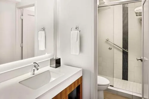 Guest bathroom vanity and shower in a City View Deluxe room at Hyatt Place Waikiki Beach.