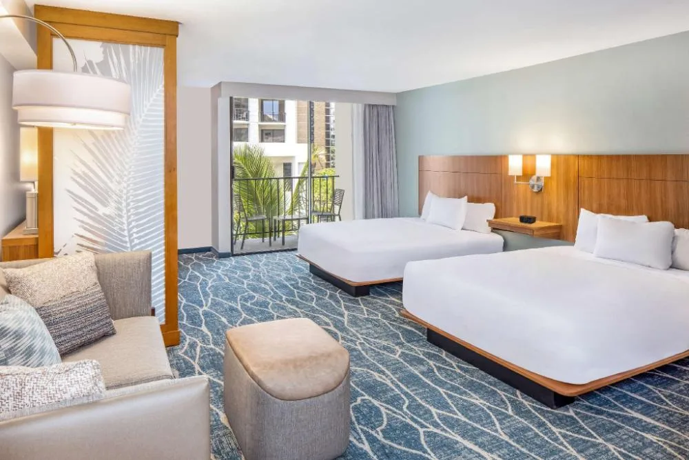 Specialty City View room with two beds, sofa bed, balcony, and seating at Hyatt Place Waikiki Beach.