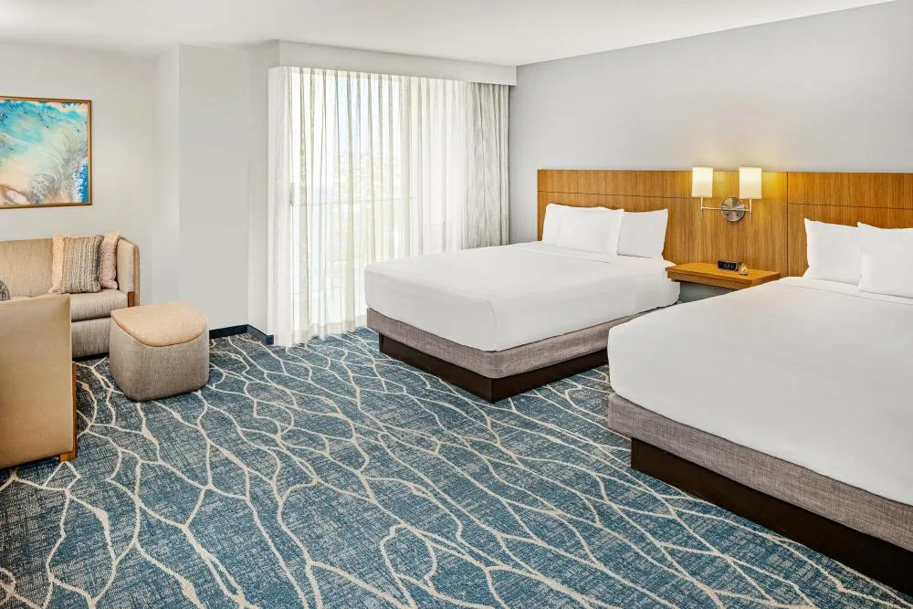 Specialty City View room with two beds, sofa bed, wall art, and sheer curtains at Hyatt Place Waikiki Beach.