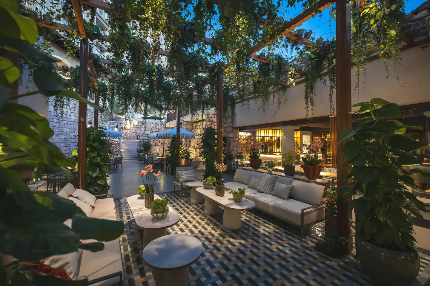 Courtyard lounge with sofas, stone walls and trailing plants at Hyatt Regency Aruba Resort and Casino.
