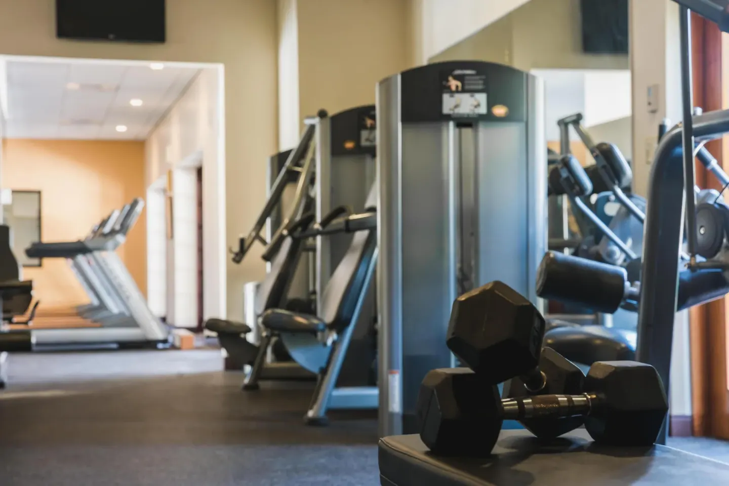 Fitness center with dumbbells, treadmills and weight machines at Hyatt Regency Aruba Resort and Casino.