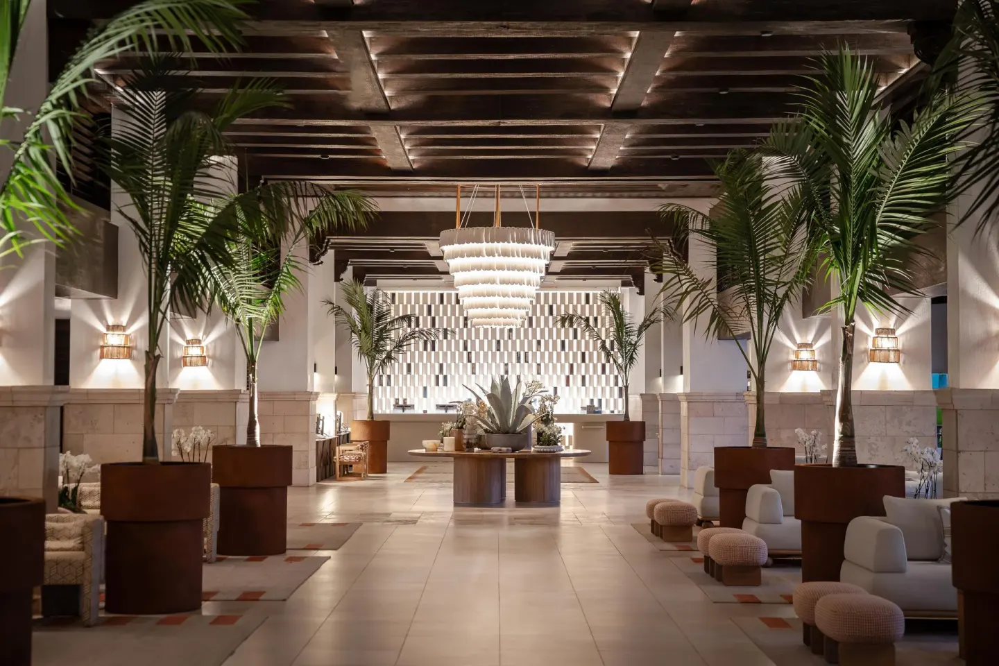 Lobby with palms, lounge seating, and a chandelier at Hyatt Regency Aruba Resort and Casino.